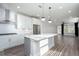 Open-concept kitchen with an island, stainless steel appliances, and hardwood floors flowing into the living area at 334 Dahlia Row Dr, Summerville, SC 29486