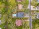 Aerial view of a neighborhood featuring homes with swimming pools, driveways, and surrounded by mature trees at 3510 Myrtle St, Edisto Island, SC 29438
