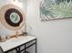 Stylish bathroom with a modern black vanity, a round mirror, and botanical artwork at 3510 Myrtle St, Edisto Island, SC 29438