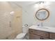 Modern bathroom featuring a glass-enclosed shower and a wood vanity with a round mirror at 3510 Myrtle St, Edisto Island, SC 29438