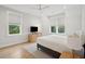 Bright bedroom with two windows, a ceiling fan, and a dresser with TV, plus light hardwood floors at 3510 Myrtle St, Edisto Island, SC 29438