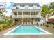 Beautifully landscaped backyard with a sparkling pool, covered outdoor living space, and a well-maintained lawn at 3510 Myrtle St, Edisto Island, SC 29438