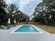 Outdoor swimming pool featuring several lounge chairs and umbrellas surrounded by a wooden privacy fence at 3510 Myrtle St, Edisto Island, SC 29438