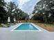 Outdoor swimming pool featuring several lounge chairs and umbrellas surrounded by a wooden privacy fence at 3510 Myrtle St, Edisto Island, SC 29438