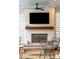 Cozy outdoor porch area featuring a fireplace, ceiling fan, and comfortable seating for relaxing or entertaining at 3510 Myrtle St, Edisto Island, SC 29438