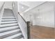 Elegant staircase with wooden treads, white risers, and a view of the open dining area at 355 Wappoo Trace Ln, Summerville, SC 29486