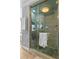 Luxurious shower with glass door and rain shower head, featuring elegant stone tile and wood-look tile flooring at 3584 Somerset Hills Ct, Mount Pleasant, SC 29466