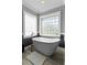 Modern bathroom with a freestanding tub, wood-look tile flooring, and plenty of natural light from two windows at 3584 Somerset Hills Ct, Mount Pleasant, SC 29466