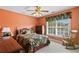 Cozy bedroom with orange walls, floral bedding, and a window with views of the neighborhood at 3584 Somerset Hills Ct, Mount Pleasant, SC 29466
