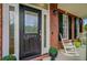 Elegant front door featuring decorative glass, gold accents, and the house number, framed by brick and a rocking chair at 3584 Somerset Hills Ct, Mount Pleasant, SC 29466