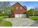 Spacious two-car garage with white doors and a paved driveway, surrounded by a landscaped yard at 3584 Somerset Hills Ct, Mount Pleasant, SC 29466