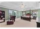 Spacious main bedroom with a four-poster bed, comfortable seating area, and neutral-toned carpet at 3584 Somerset Hills Ct, Mount Pleasant, SC 29466