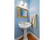 Charming powder room with a pedestal sink, gold fixtures, and light blue walls at 3584 Somerset Hills Ct, Mount Pleasant, SC 29466