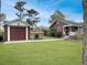 Well-maintained backyard with lush lawn, a detached garage, and a charming pergola at 402 N Hickory Street St, Summerville, SC 29483