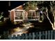Charming red home at night with a screened porch, illuminated pathway, and inviting ambiance at 402 N Hickory Street St, Summerville, SC 29483