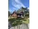 Charming red home features a screened-in porch, manicured lawn, and a classic American flag at 402 N Hickory Street St, Summerville, SC 29483