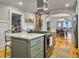 Kitchen island with gas range, marble countertop, seating, and an open layout to the dining area at 402 N Hickory Street St, Summerville, SC 29483