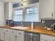 Butcher block counters compliment white cabinets and stainless steel appliances in this kitchen, situated under a window at 402 N Hickory Street St, Summerville, SC 29483