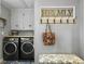 Convenient laundry room featuring a washer and dryer, storage cabinets, and a decorative coat rack at 402 N Hickory Street St, Summerville, SC 29483