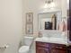 Powder room featuring a cherry vanity, framed floral art, and light fixtures at 4029 Gift Blvd, Johns Island, SC 29455