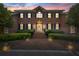 Stately two-story red brick home with symmetrical design, black shutters, and meticulously maintained landscaping at 4029 Gift Blvd, Johns Island, SC 29455
