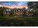 Elegant brick home with a beautifully landscaped front yard, showcasing curb appeal and classic design under a colorful sunset at 4029 Gift Blvd, Johns Island, SC 29455