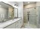 Bathroom featuring dual sinks, a large mirror, and tiled walk-in shower at 4060 S Rhett Ave, North Charleston, SC 29405
