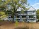 A three-story townhome boasts a private balcony, blending modern architecture with outdoor living at 4060 S Rhett Ave, North Charleston, SC 29405