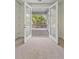 View from inside a home, through French doors, showcasing a covered balcony with wood floors and white railings at 4235 Royal Harbor Rd, Hollywood, SC 29449