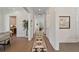 Bright hallway featuring hardwood floors, white trim, a patterned runner rug, and stylish decor at 4235 Royal Harbor Rd, Hollywood, SC 29449