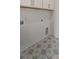 Laundry room with gray starburst tile flooring and white cabinets above the hookups for a washer and dryer at 4235 Royal Harbor Rd, Hollywood, SC 29449