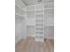 Bright walk-in closet featuring custom white shelving and a built-in ladder for easy access to higher storage areas at 4235 Royal Harbor Rd, Hollywood, SC 29449