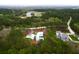 An aerial view of a modern white home surrounded by lush greenery, a golf course, and a beautiful marsh landscape at 4310 Stonehouse Cir, Awendaw, SC 29429