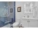 Elegant bathroom features a blue tiled glass shower, white vanity, and decorative framed mirror at 4310 Stonehouse Cir, Awendaw, SC 29429