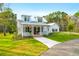 Charming two-story home with a metal roof, inviting front porch, and lush landscaping at 4310 Stonehouse Cir, Awendaw, SC 29429