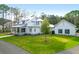 Stunning white farmhouse-style exterior with a lush green lawn and an inviting front porch at 4310 Stonehouse Cir, Awendaw, SC 29429