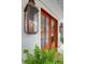 Elegant wood front door with glass panels and decorative lantern lighting at 4310 Stonehouse Cir, Awendaw, SC 29429