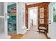 Stylish hallway with bold wallpaper, contrasting teal pantry, and a view of the shiplap-lined staircase at 4310 Stonehouse Cir, Awendaw, SC 29429