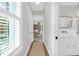 Bright hallway featuring hardwood floors, white trim, and a view into the living room at 4310 Stonehouse Cir, Awendaw, SC 29429
