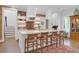 Open-concept kitchen with a large island, seating, brick backsplash, and modern lighting at 4310 Stonehouse Cir, Awendaw, SC 29429