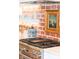 Modern kitchen featuring stainless steel range and brick backsplash with decorative hanging artwork at 4310 Stonehouse Cir, Awendaw, SC 29429