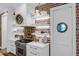 Well-lit kitchen with brick backsplash, white shelving, porthole door, and stainless steel range at 4310 Stonehouse Cir, Awendaw, SC 29429