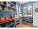 Well-organized pantry with custom blue shelving, butcher block countertops, and multiple windows at 4310 Stonehouse Cir, Awendaw, SC 29429