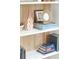 Close-up of living room shelf displaying books, artwork, and decor items at 4310 Stonehouse Cir, Awendaw, SC 29429