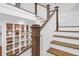 Elegant staircase featuring white railings, wood steps, and open shelving at 4310 Stonehouse Cir, Awendaw, SC 29429