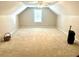 Finished attic featuring neutral walls, carpet, window, and ceiling fan providing a bright and spacious living area at 5182 Forest Oaks Dr, Hollywood, SC 29449
