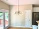 Bright dining area with hardwood floors, chandelier, and door leading to the backyard at 5182 Forest Oaks Dr, Hollywood, SC 29449