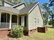 Charming home exterior with a brick foundation, siding, well-maintained landscaping, and a welcoming porch at 5182 Forest Oaks Dr, Hollywood, SC 29449
