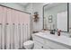Bright bathroom with a single sink vanity, decorative shelves, and a stylish shower curtain at 5560 Alpine Dr, Summerville, SC 29483