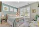 Charming bedroom with patterned bedspread and bright natural light from multiple windows at 5560 Alpine Dr, Summerville, SC 29483